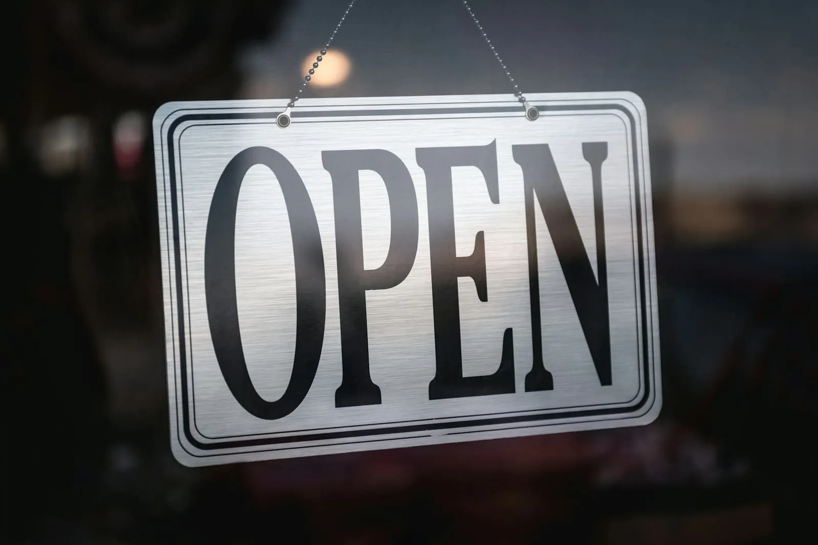 Bordje met het woord open aan de glazen deur van een lokale zaak