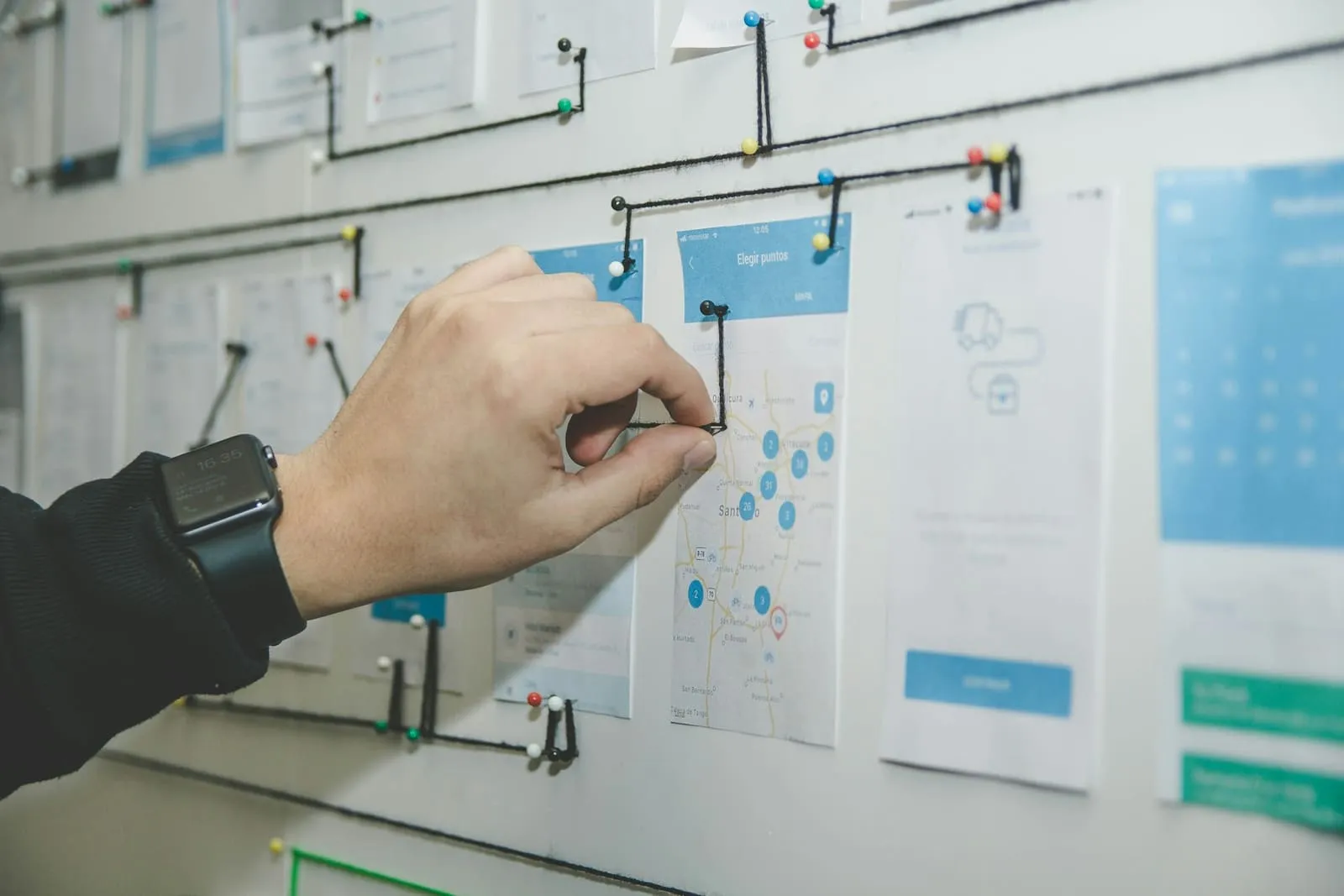 Hand prikt een app-schets met een kaartweergave op een wand vol ontwerpen